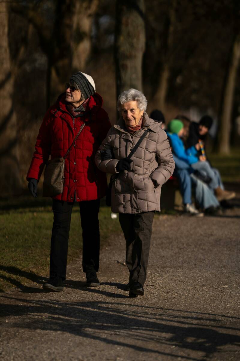 dame âgée qui marche dans un parc accompagné d'une autre dame d'une quarantaine d'années